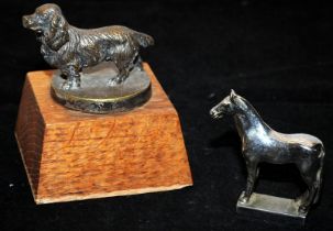 Two vintage car mascots, a chrome horse and a brass spaniel mounted on a wooden plinth. O/all height