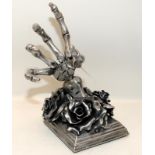 Sculptural Gothic black rose with skeletal hand bottle holder cast in metal. 28cms tall