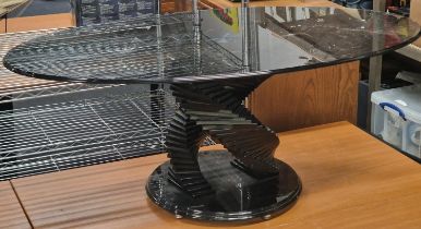 Contemporary smoked black glass oval coffee table on stepped glass base 120x48x66cm.