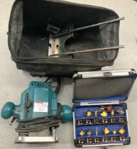 A Makita Router with various attachments and bag.