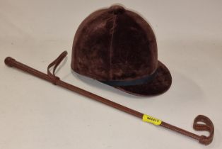 A Super Beaufort horse riding helmet size 7/57 together with a riding crop.