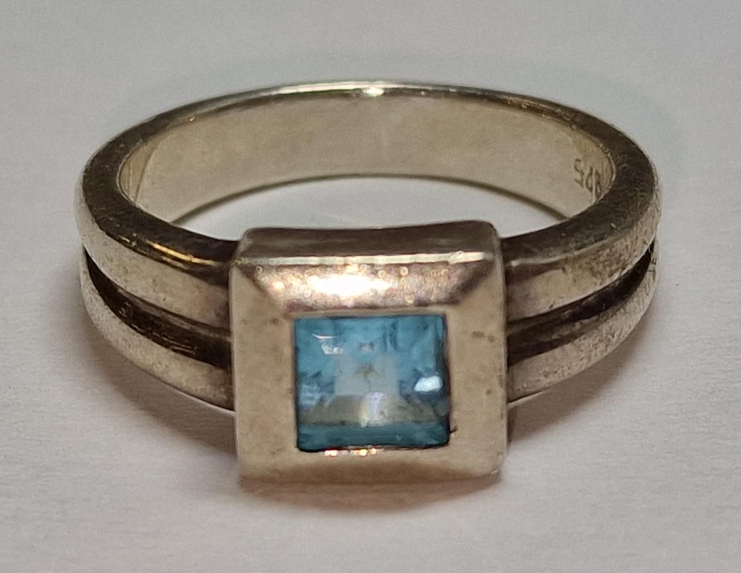 A 925 silver and square cut blue stone ring Size M