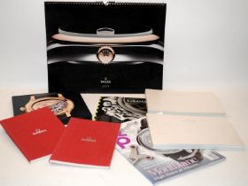 A collection of quality watch publications to include Omega catalogues and a Rolex calendar