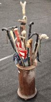 Vintage stick stand with contents of various walking sticks and a brolly.