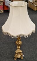 A large gilt table lamp with shade.