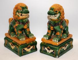 Pair of large ceramic Dogs of Fo in green/orange glaze. 34cms tall