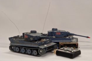 Two remote controlled tanks together with one controller and a boxed accessory pack.