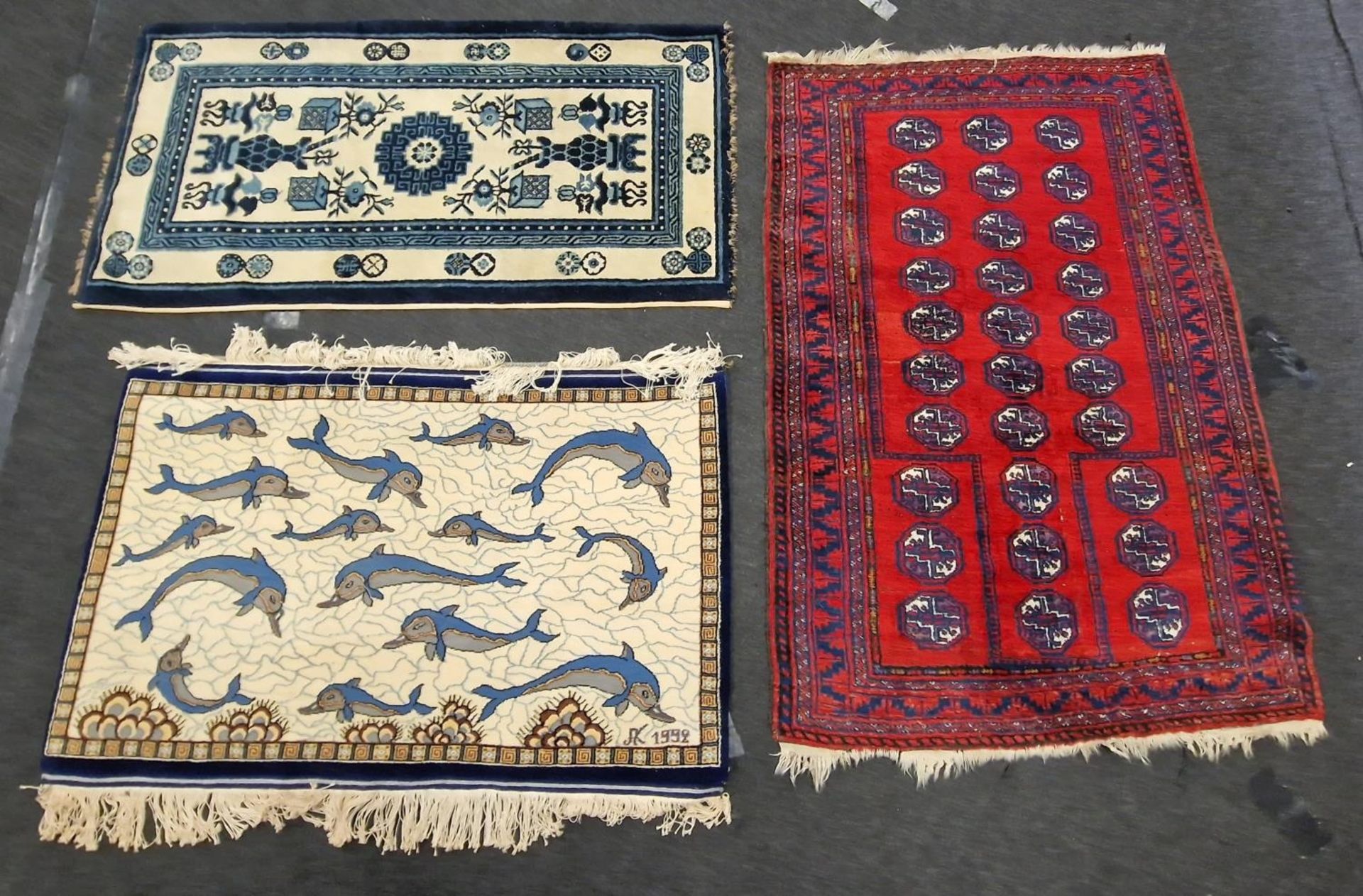 A group of three vintage carpets to include a Bokhara and a Chinese example.