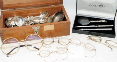A wooden box containing flatware and a small bowl with an inset George III silver coin, other plated