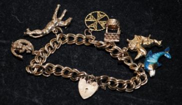 9ct gold charm bracelet with padlock clasp and safety chain attached. includes 6 charms. 24.7g