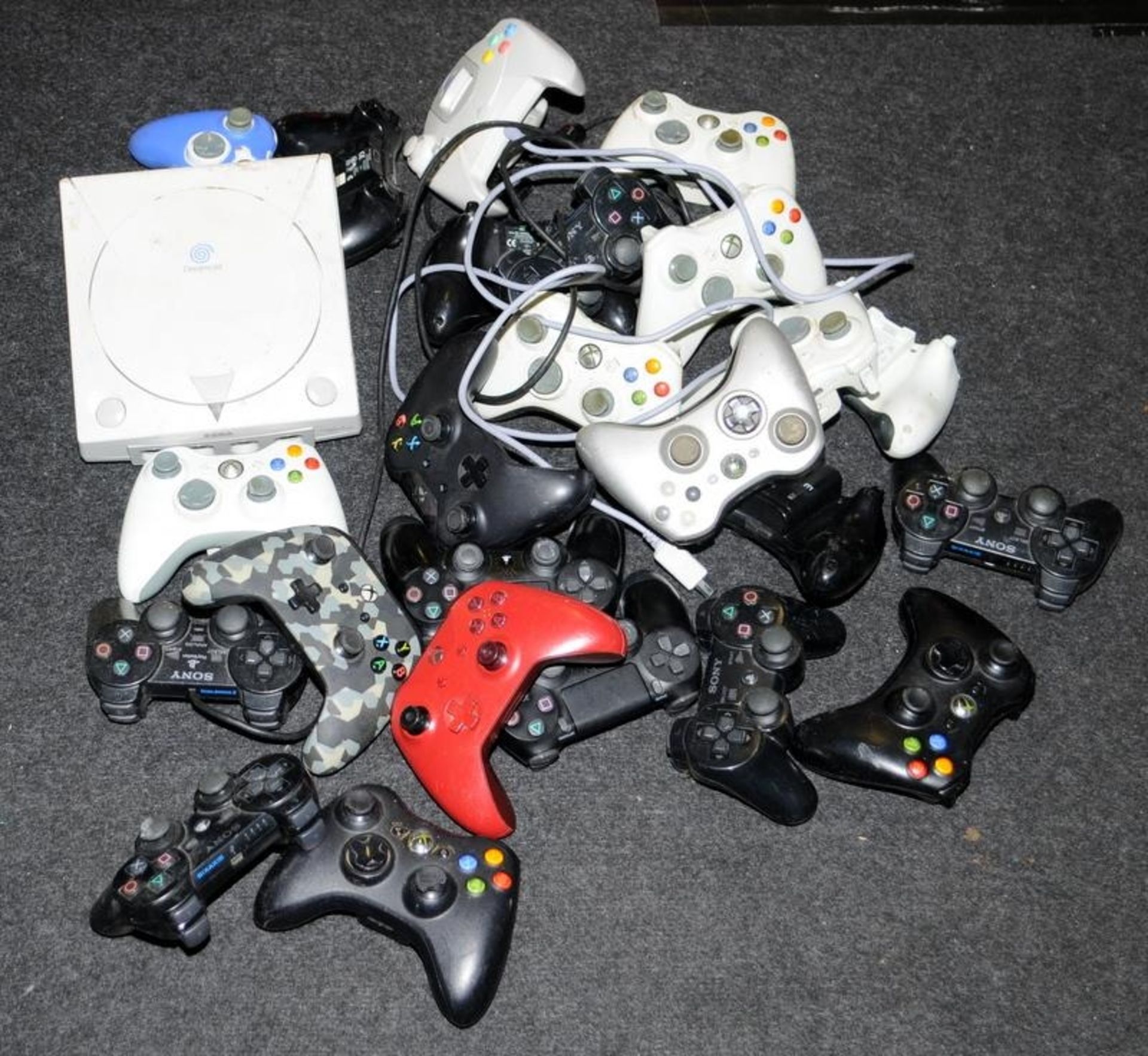 A large quantity of games controllers. Various makes and models c/w a Dreamcast console