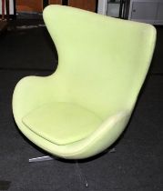 Contemporary green upholstered swivel egg chair on chrome base.