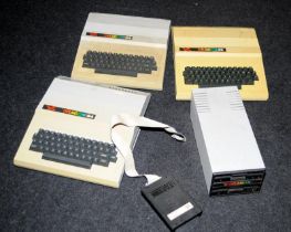 Collection of vintage Dragon home computers and a floppy disc drive