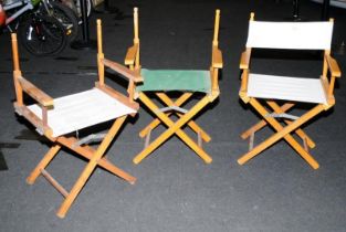 Three canvas on wood frame folding chairs in the directors style.