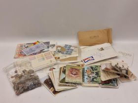 A collection of stamps, postcards and a small bag of mixed coins.