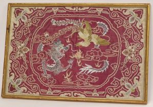 Chinese framed and glazed silk panel on red ground depicting a dragon and bird 62x42cm.