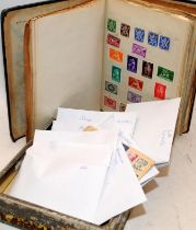 A collection of vintage stamps contained within an album and a tin