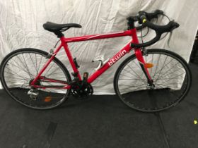 A red Btwin Triban 3 aluminium 6061 racing bike with carbon fork and Shimano gears .