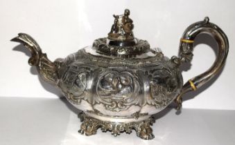 A superb example of a Georgian silver Tea pot heavily embossed with blank cartouche and surmounted