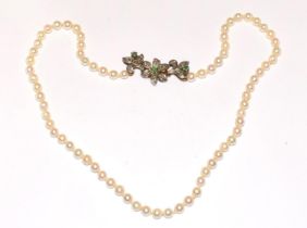 A pearl necklace with 18ct gold clasp, diamonds and sapphires set into the clasp with silver top.