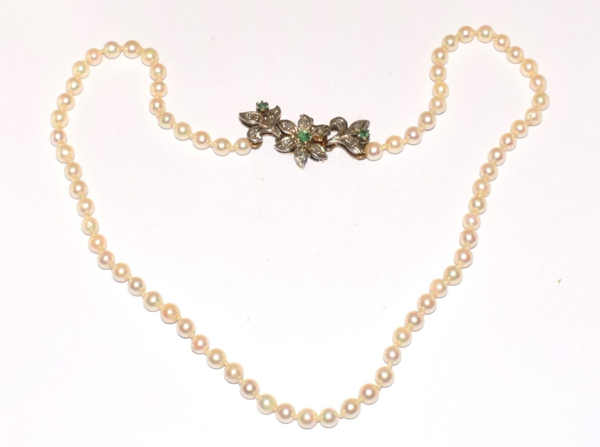 A pearl necklace with 18ct gold clasp, diamonds and sapphires set into the clasp with silver top.