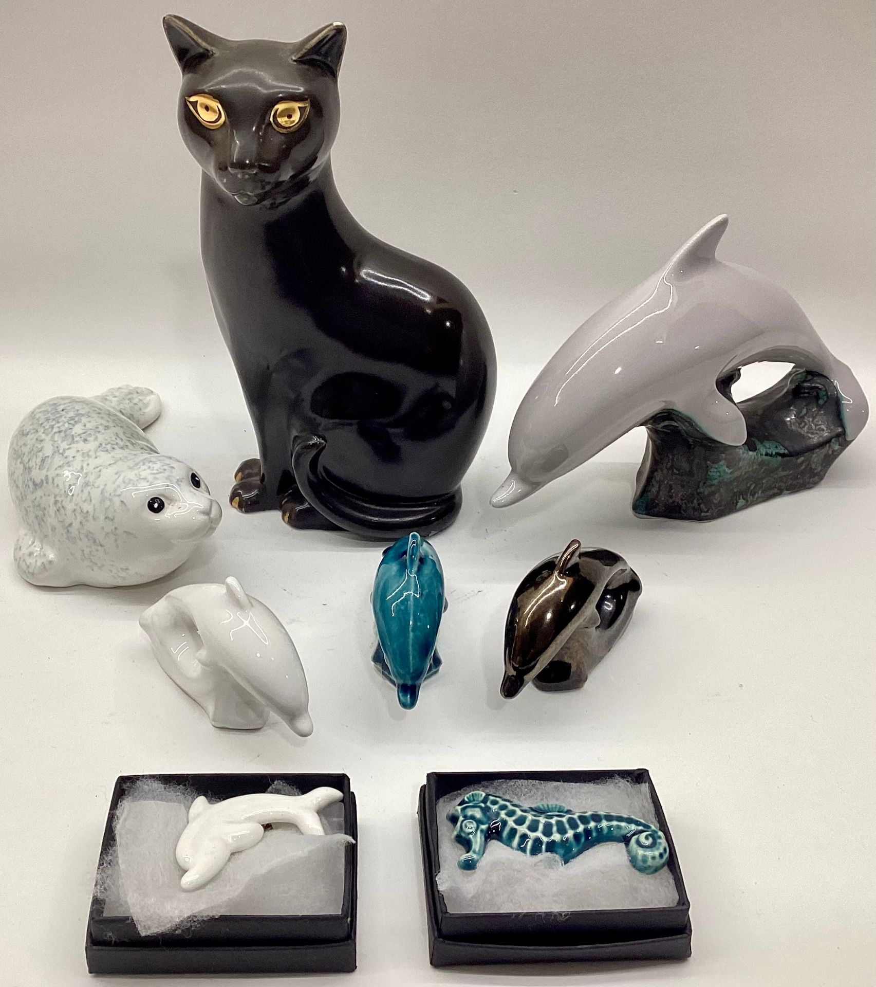 Poole Pottery unusual coloured Dolphin, together with three miniature Dolphins, Seal & small cat,