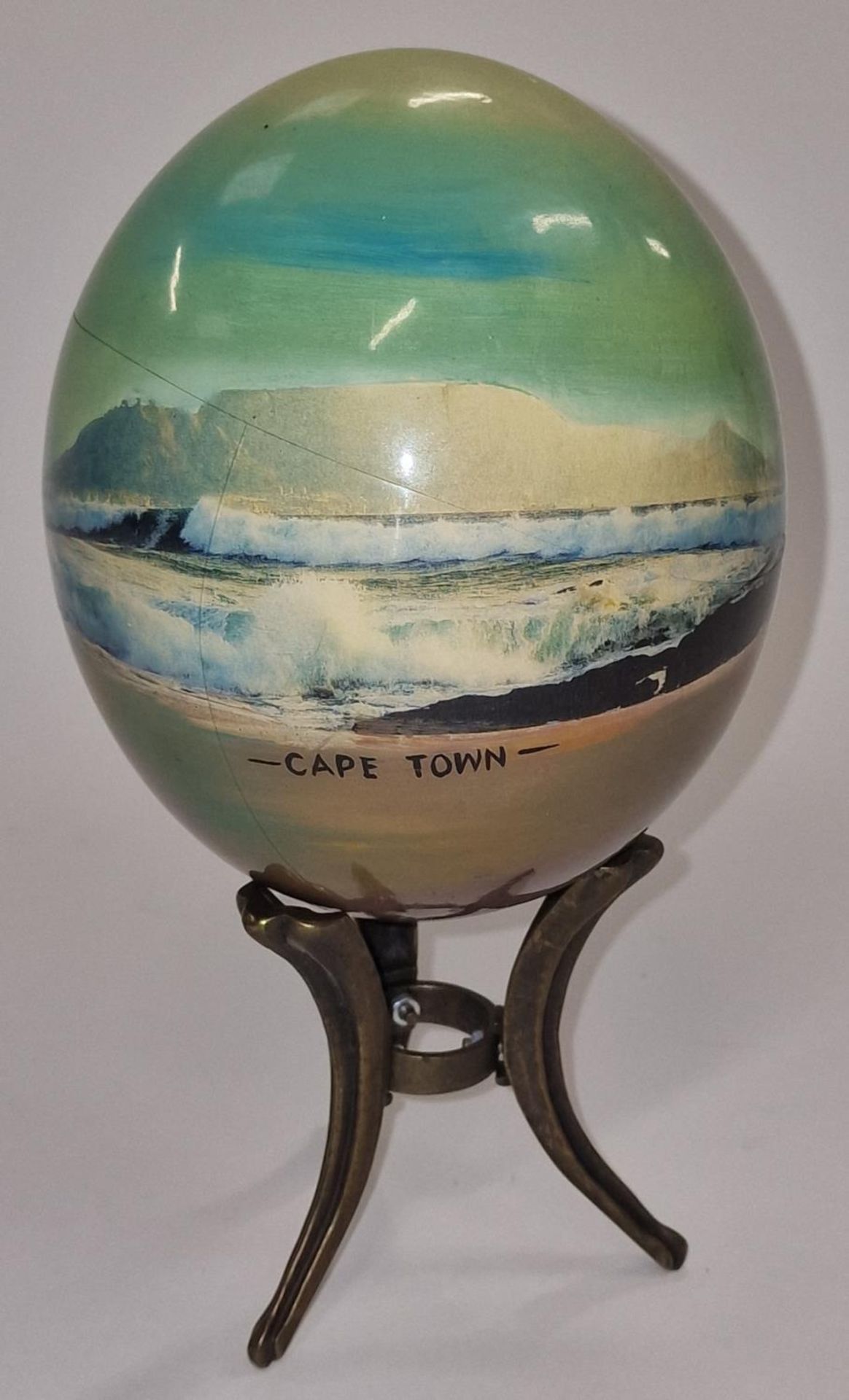 A painted ostrich egg on stand by "Julie Morgan" signed.