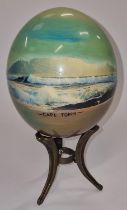 A painted ostrich egg on stand by "Julie Morgan" signed.