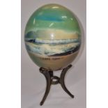 A painted ostrich egg on stand by "Julie Morgan" signed.