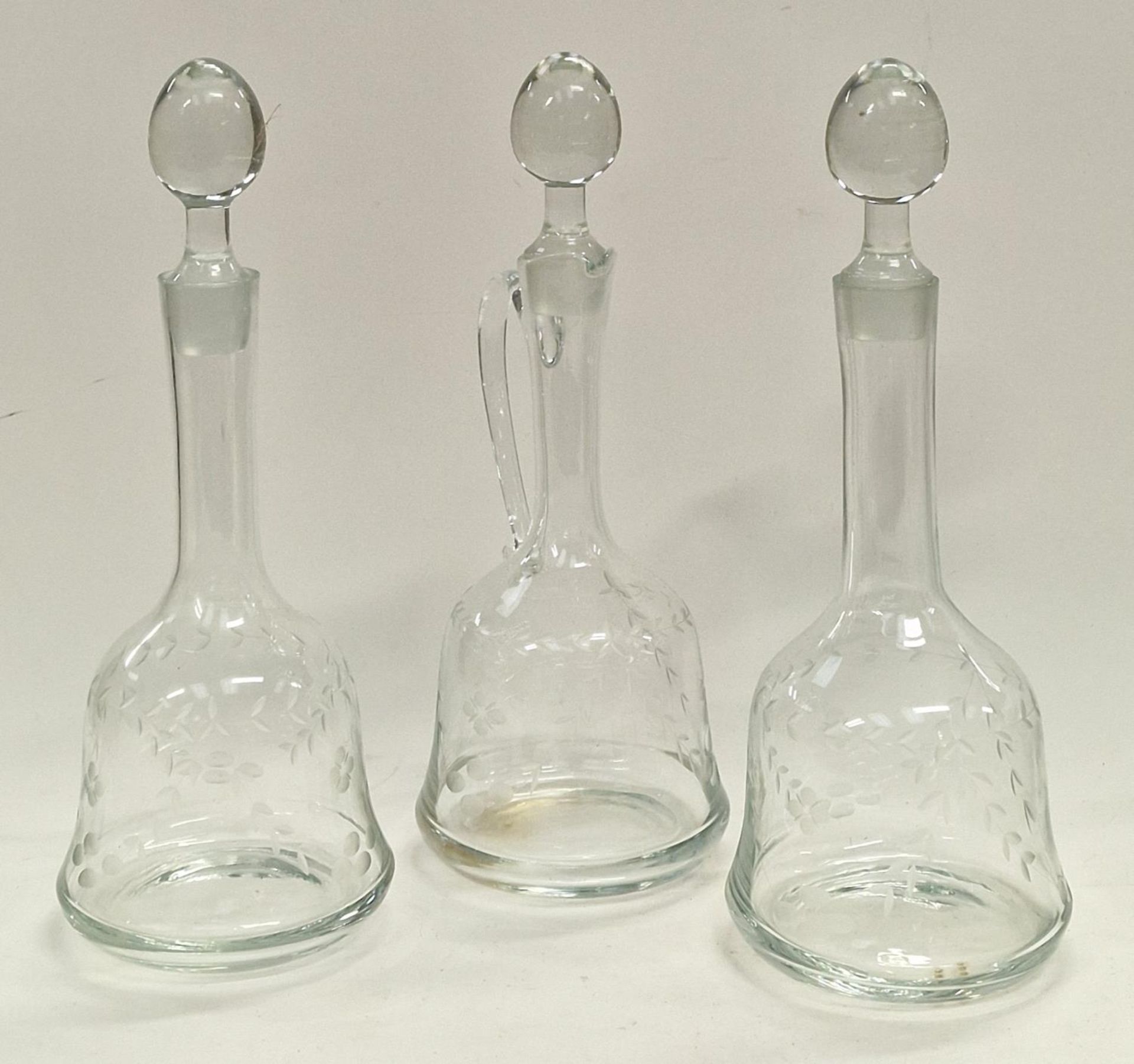 Three etched glass decanters with stoppers.