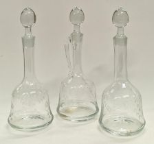 Three etched glass decanters with stoppers.