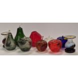 A collection of coloured glass fruits together with a pair of glass candlesticks.