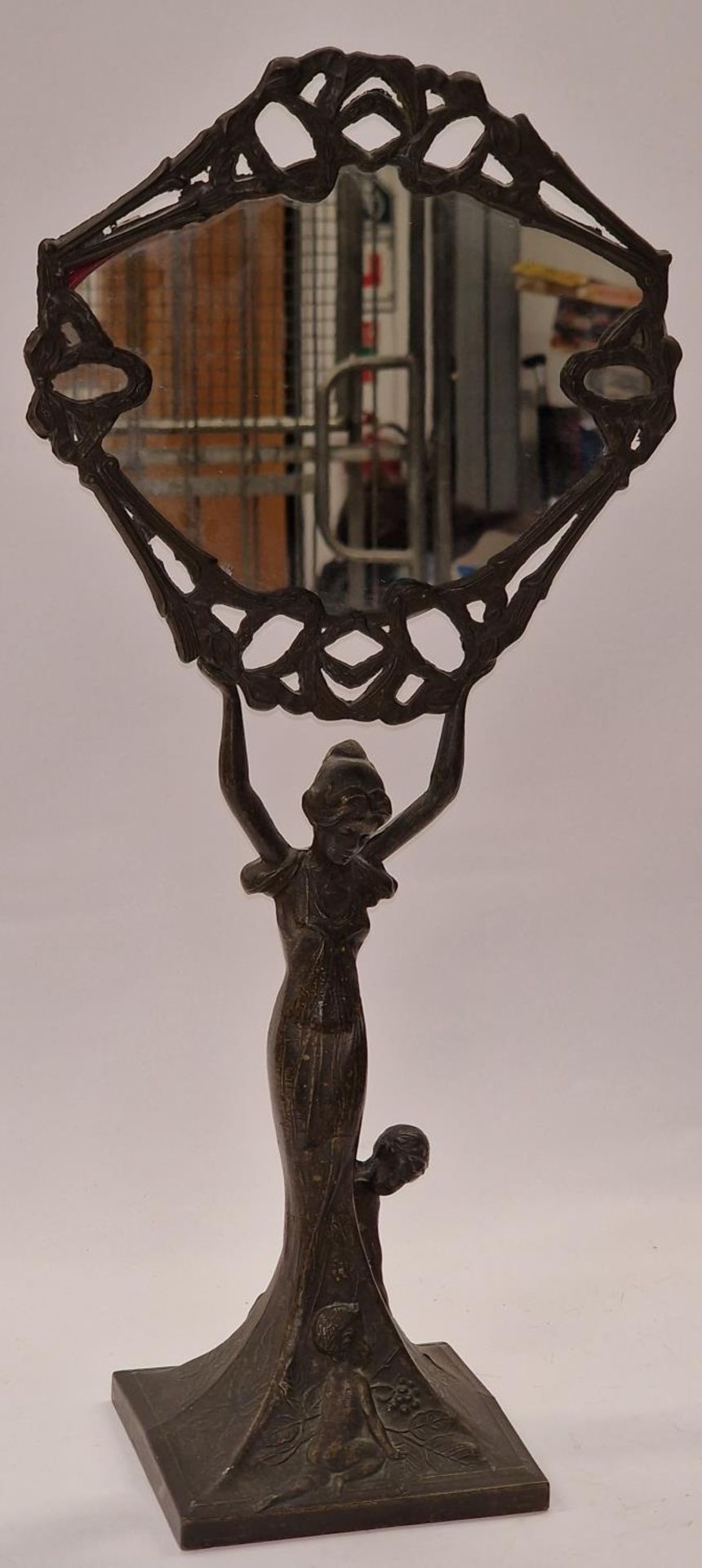 A decorative metal Art Nouveau style mirror depicting a lady 50cm tall.
