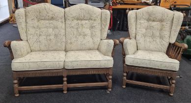 An Ercol two seater settee and matching armchair both with floral cushions.