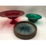 A cranberry glass centre piece together with a green glass bowl and one other.