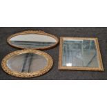 A collection of three vintage gilt framed mirrors two oval shaped and one square.