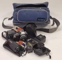 Olympus OM10 camera together with some lenses and accessories in an Olympus carry bag.