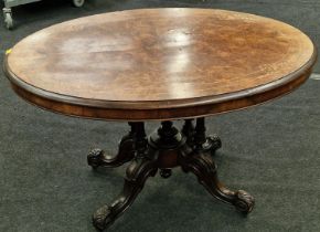 Victorian burr walnut oval tilt top loo table on ornate four column base with castors 74x120x88cm.