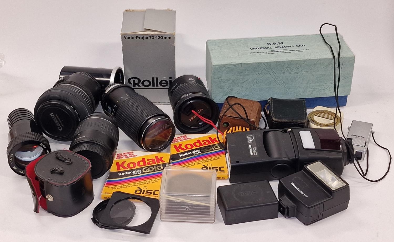 Collection of camera lenses, flashes and other accessories.