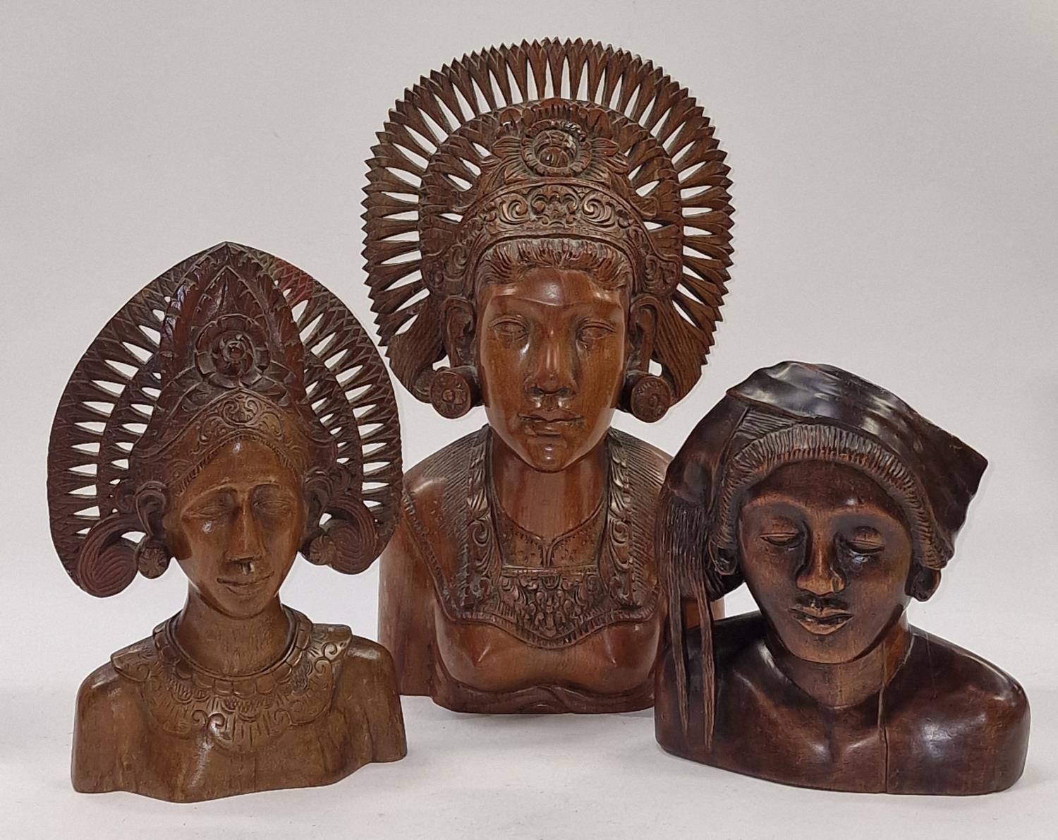 Collection of Indonesian wooden carved busts of varying sizes.