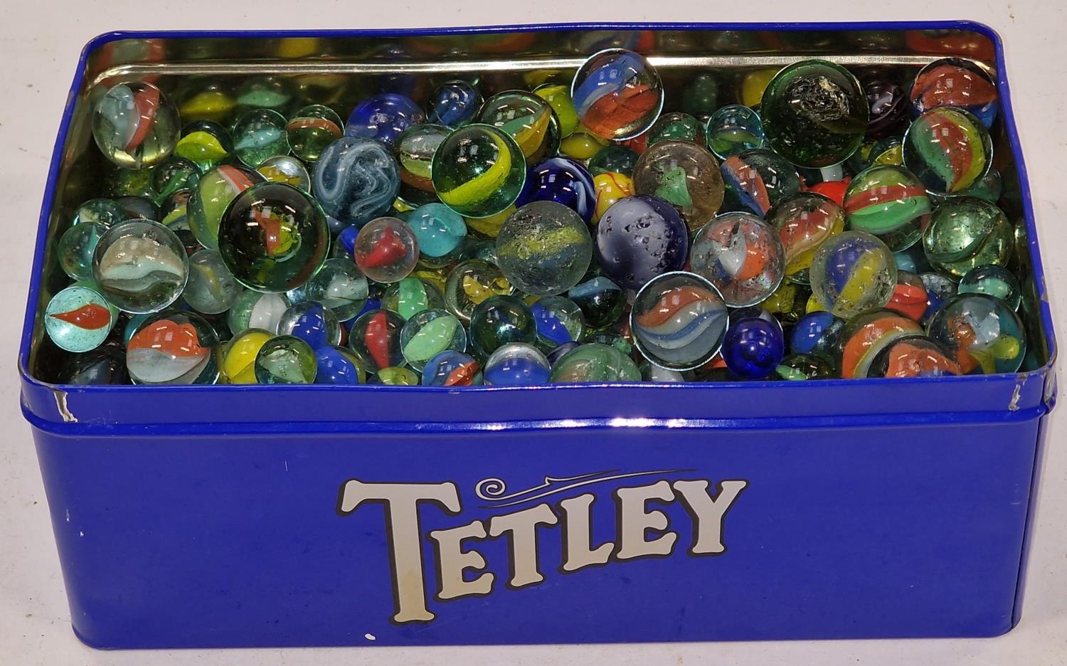 A tin of various marbles. Various sizes.