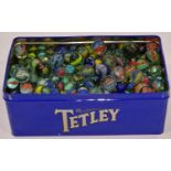 A tin of various marbles. Various sizes.