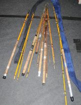 A collection of vintage fibre glass and cane fishing rods