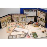 An album of Royal Mail stamps postcards, an album of First Day Covers, a schoolboy stamps album