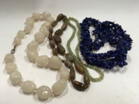 A large collection of natural stone necklaces to include Blue Lapis and Jade