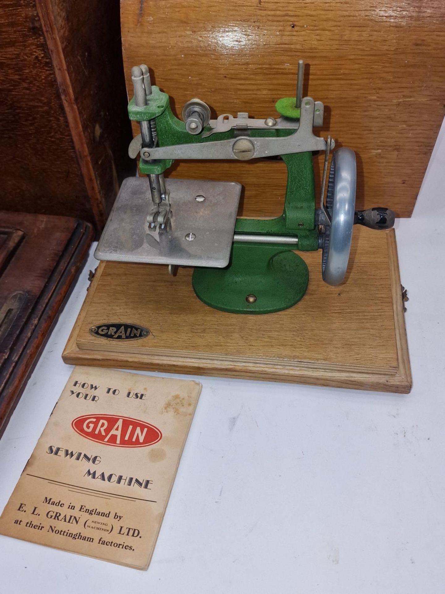 Vintage Grain miniature toy sewing machine together with a larger sewing machine. - Image 2 of 3