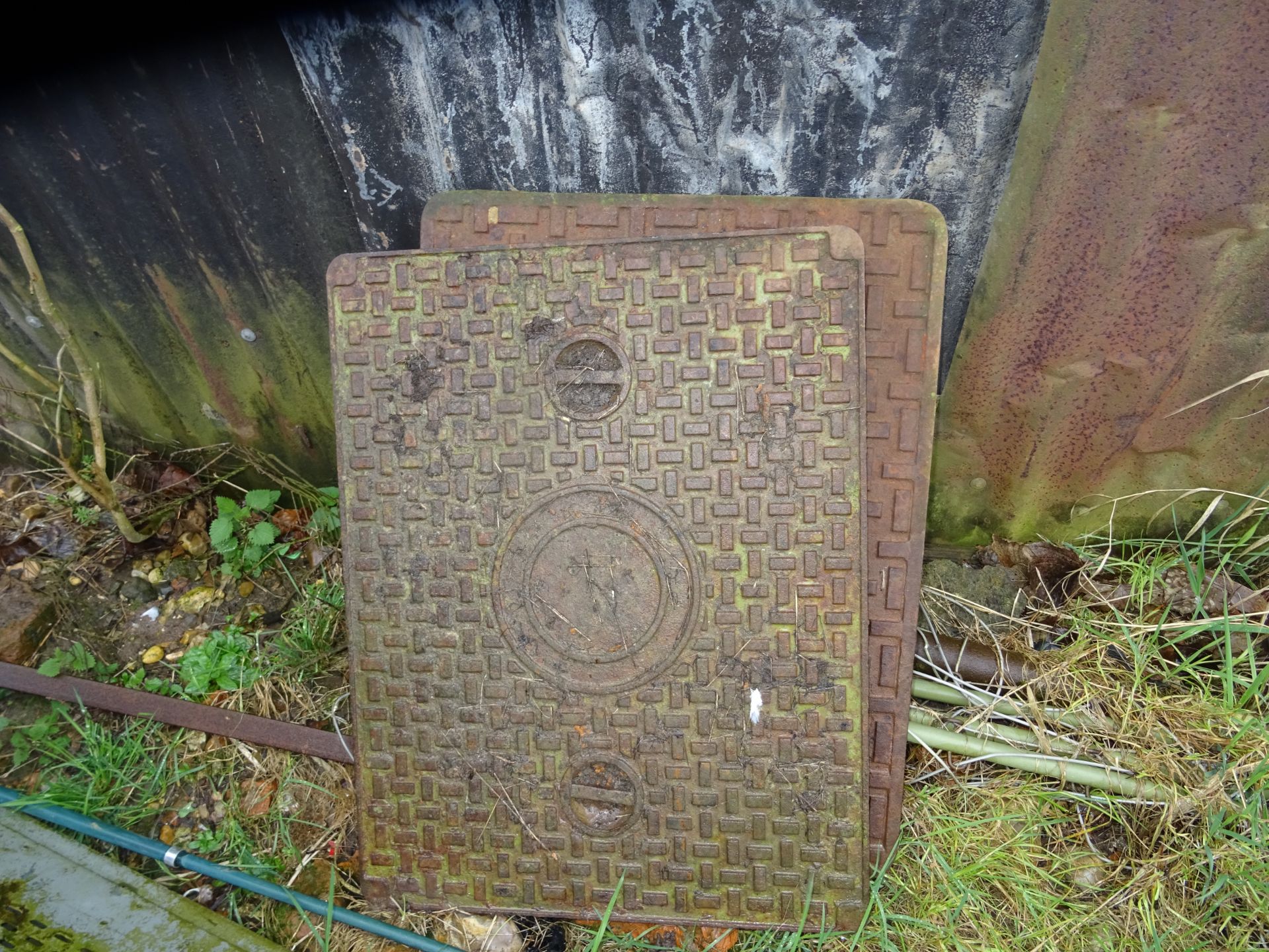 TWO CAST IRON MANHOLE COVERS