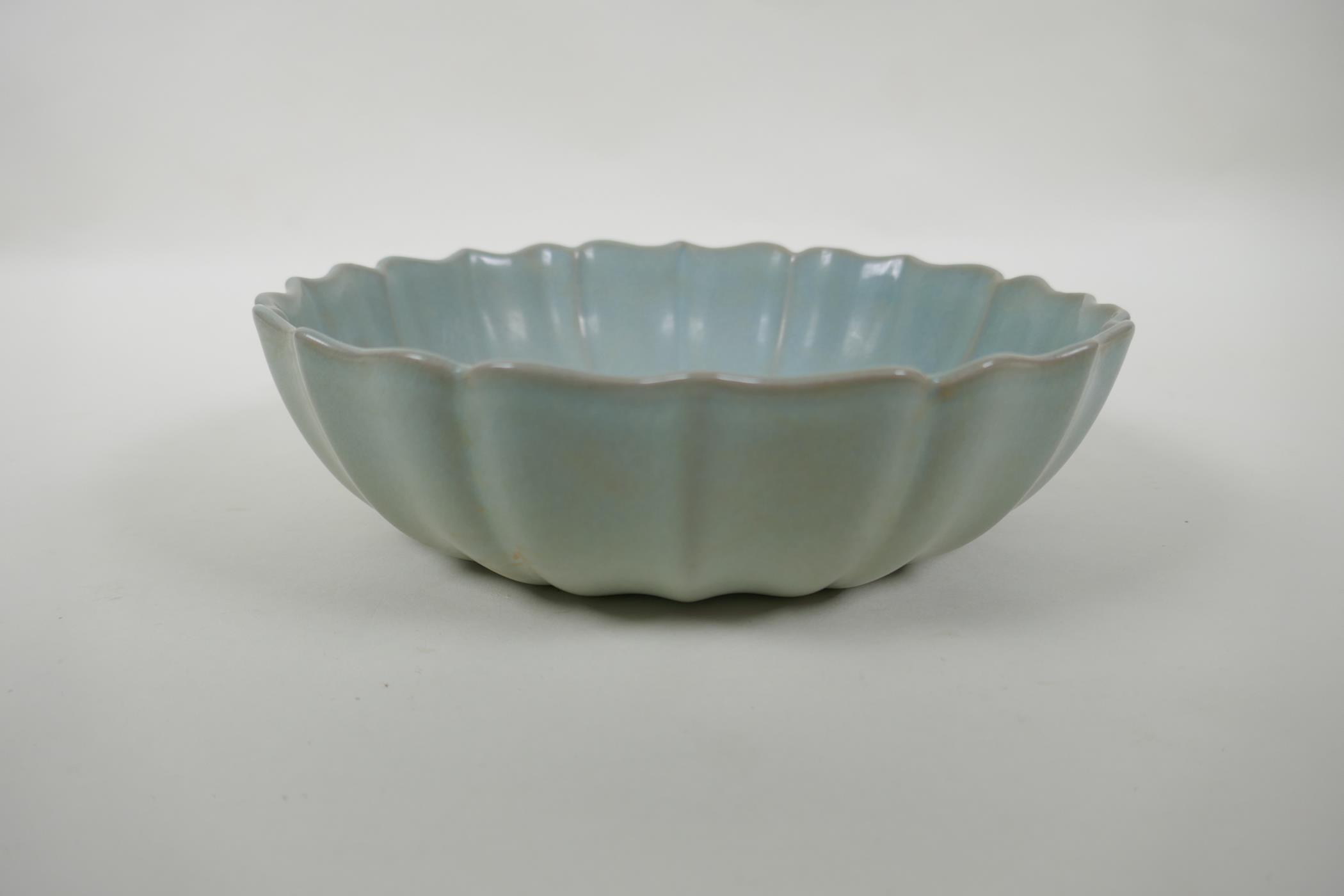 A Chinese Ru ware style bowl with a petal shaped rim, the bowl with chased and gilt character