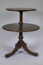 A C19th oak dumb waiter, the two revolving tiers with dished tops, raised on a fluted turned