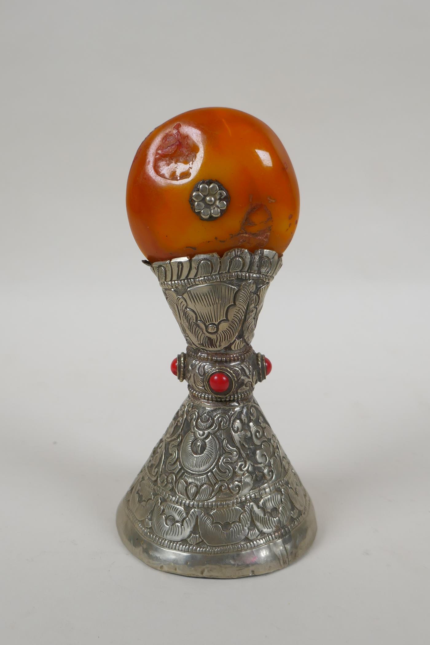 A Tibetan white metal temple seal set with a faux amber rondel, 16cm high